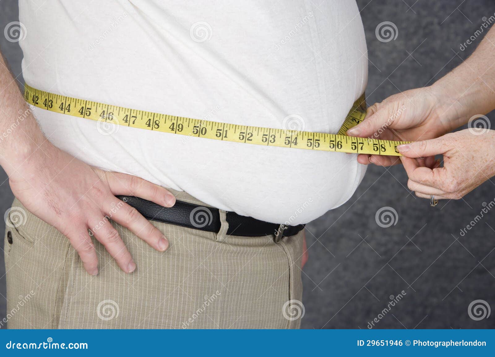hands measuring abdomen of obese man
