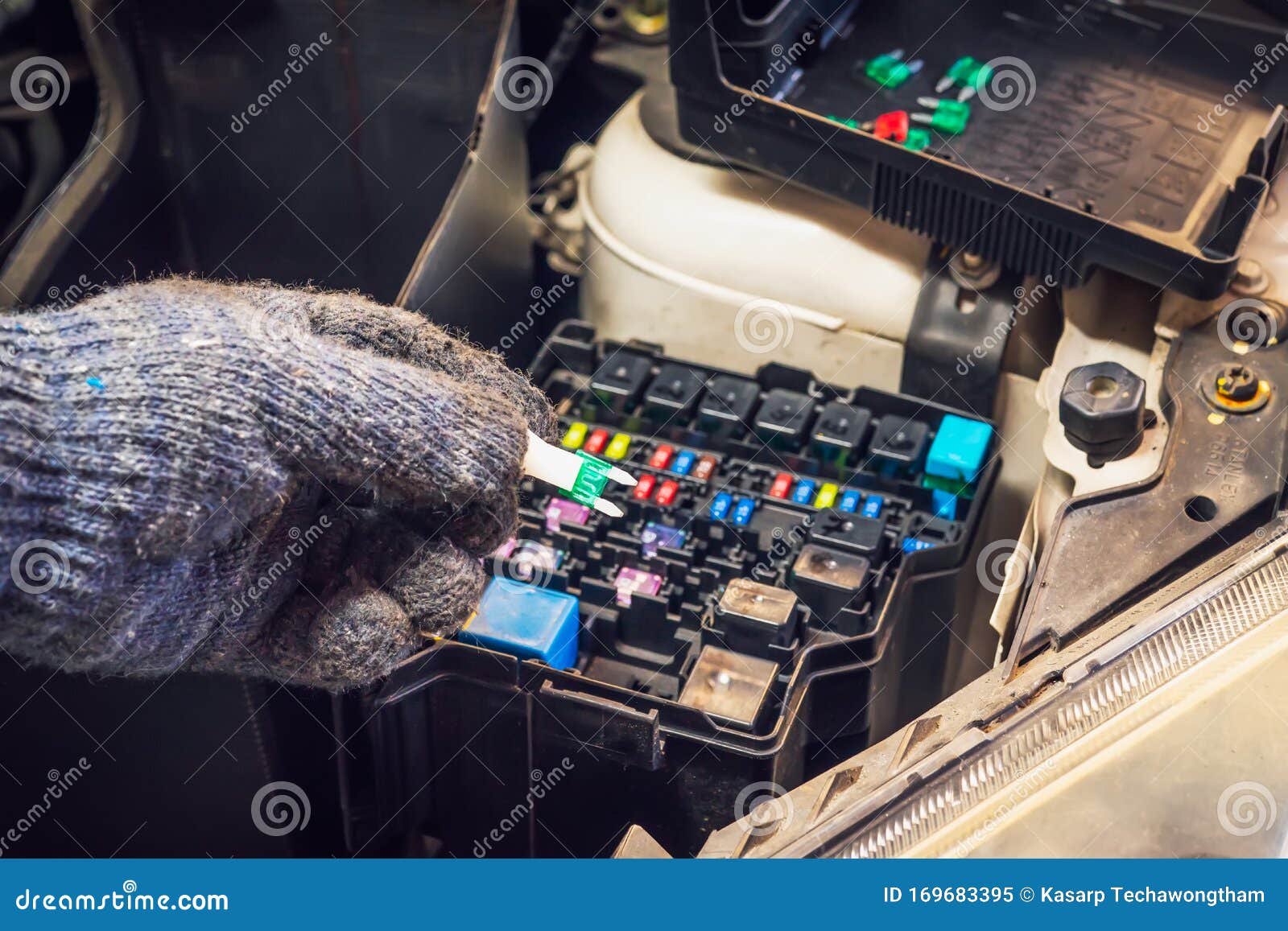 The Hands of the Mechanic Replacing Fuse in Car and Selects the Correct
