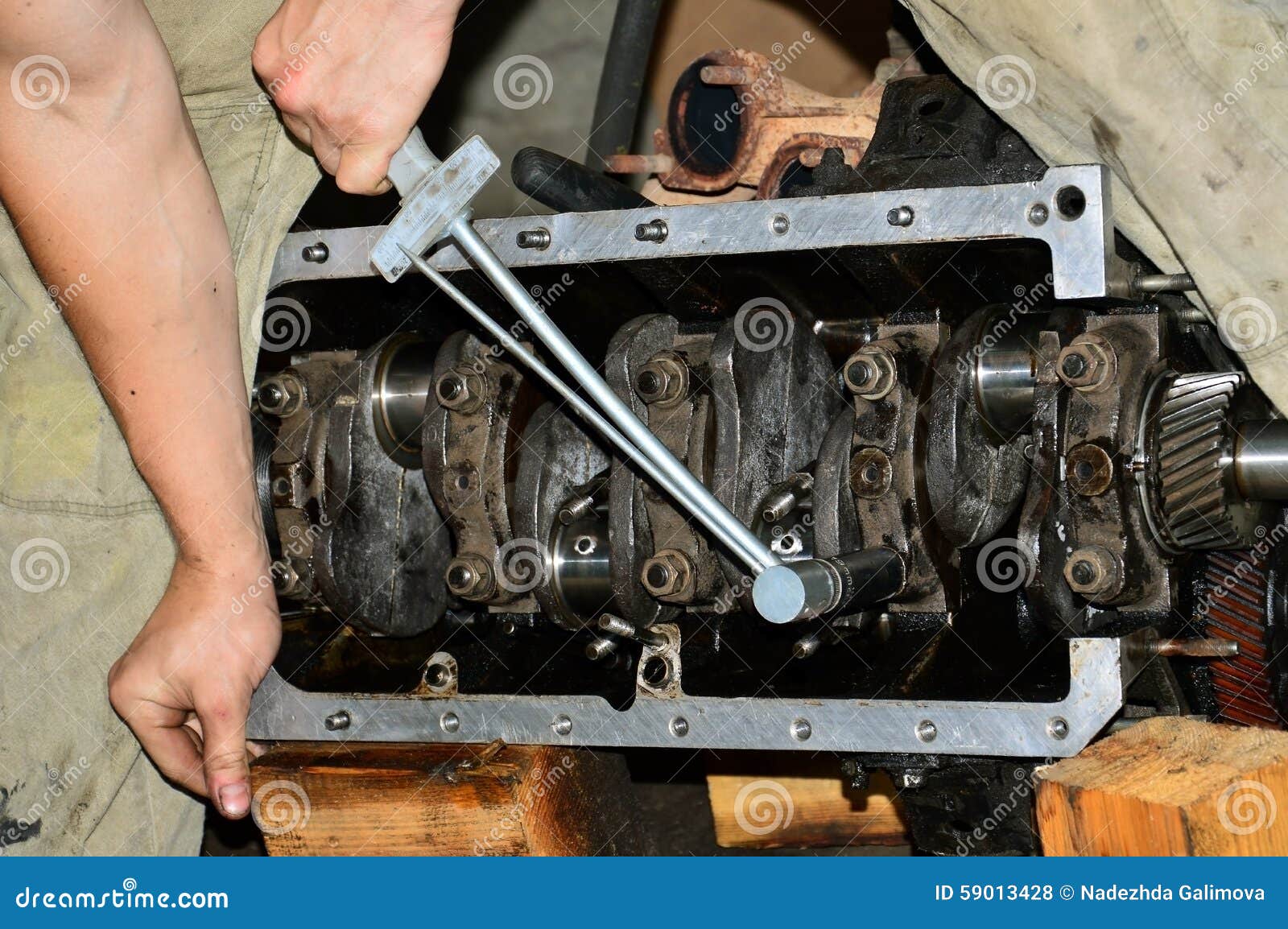 Hands of Mechanic Stretch Cap Main Bearings of an Internal Combustion