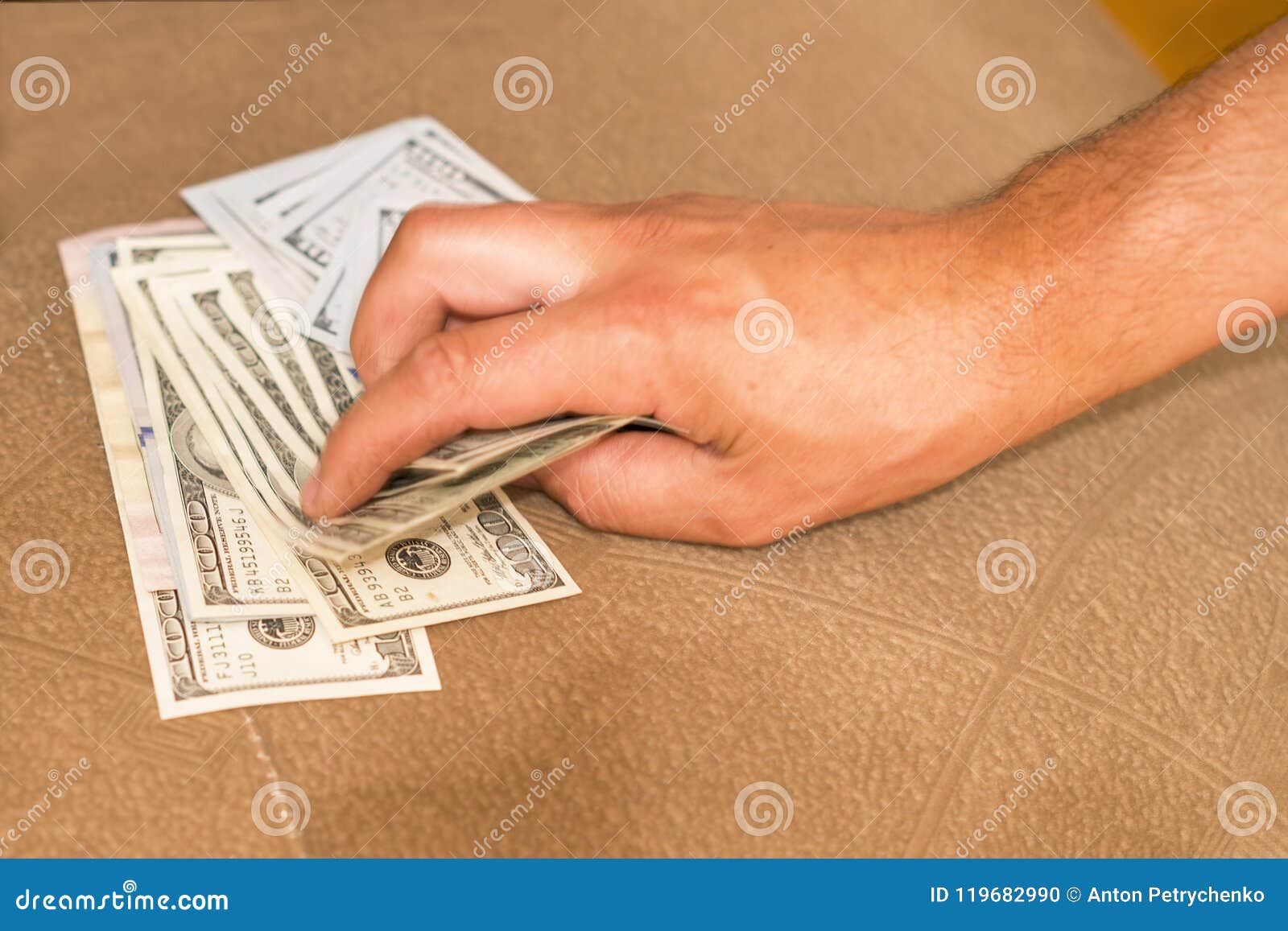 hands with money hide them under mattress. a man`s hand takes money from under the pillow. a man hides money in a bed
