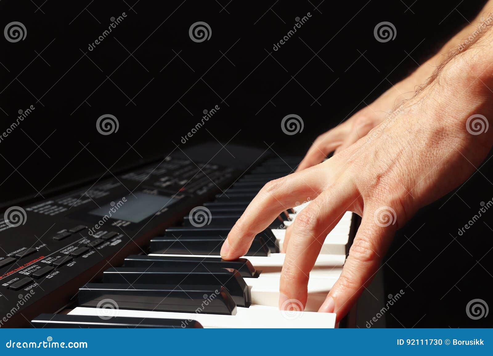 Hands of Musician Playing the Electronic Synth on Black Background