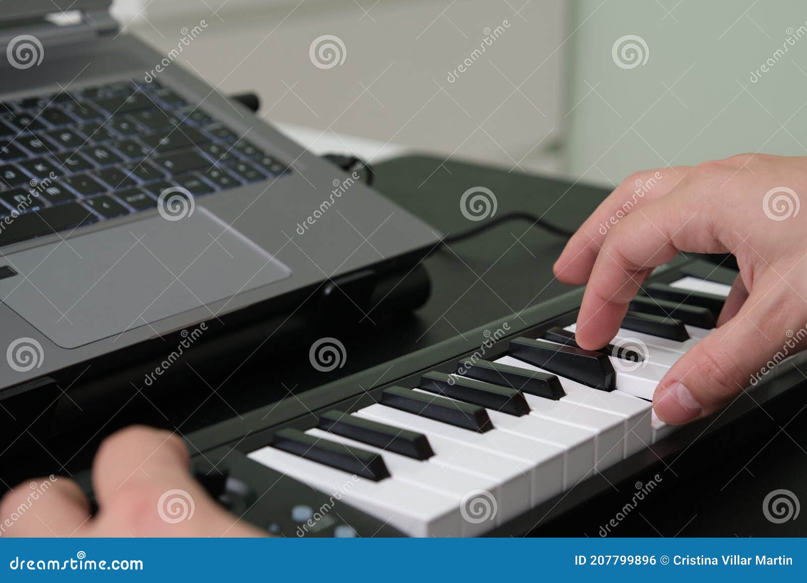 Hands Playing the Electronic Piano in Front of the Laptop Stock Photo