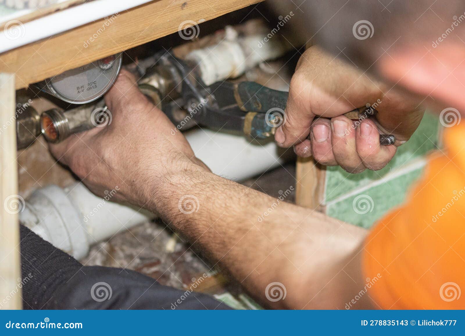 Hands of Plumber Hold an Adjustable Wrench, Pipe Replacement Stock