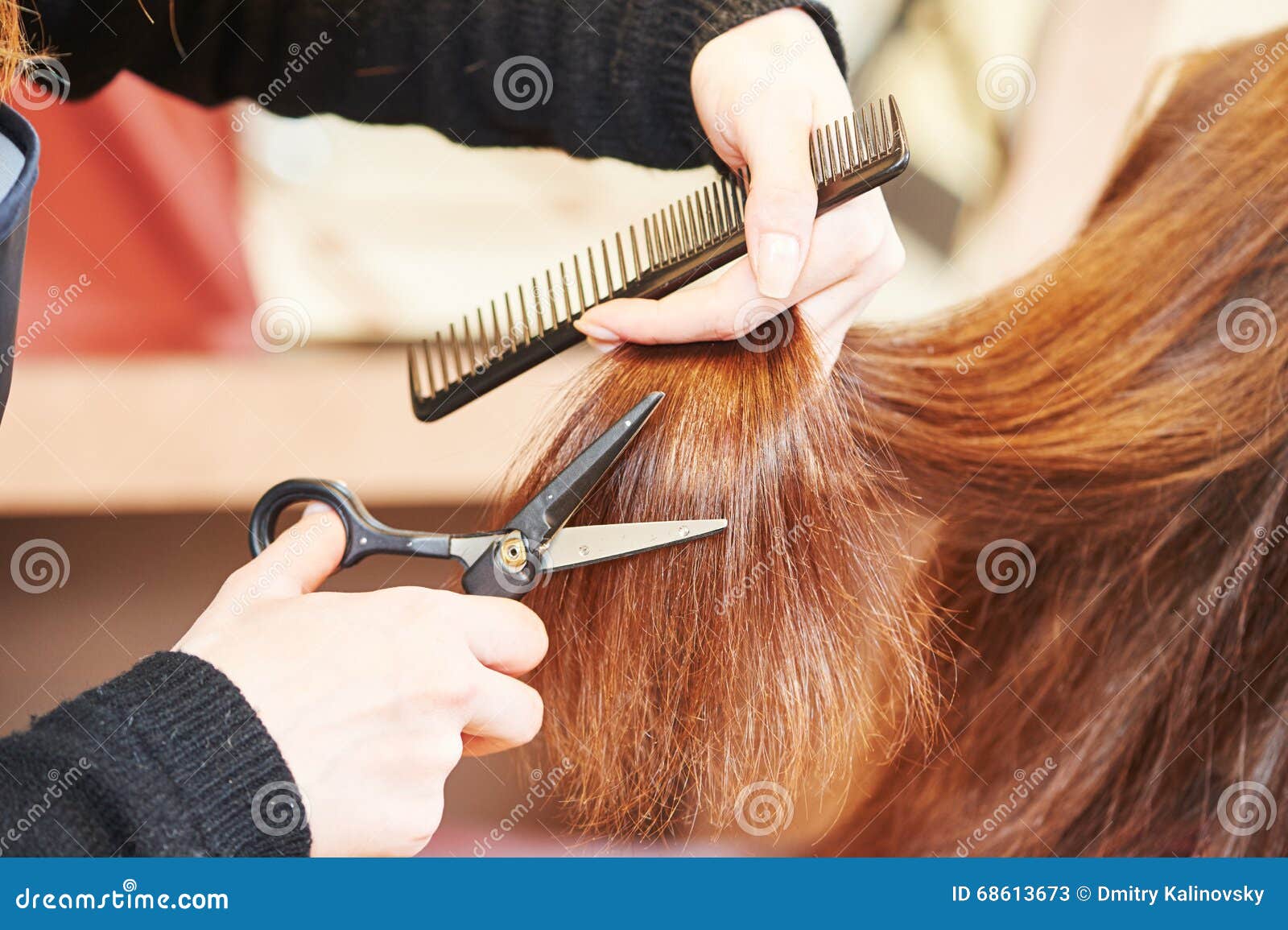 hands of professional hair stylist with scissors and comb