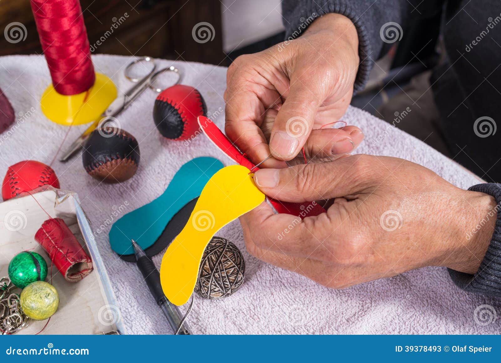 hands sewing pelota balls