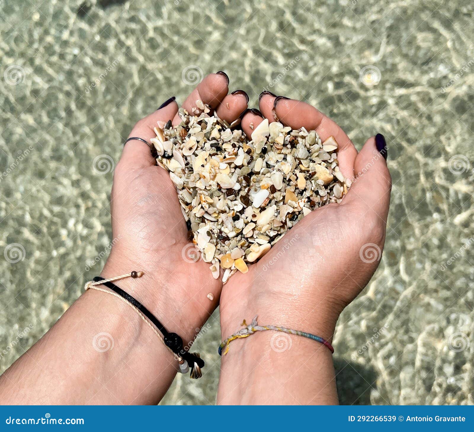 hands in the  of a heart with shells from playa conchal beach in costa rica