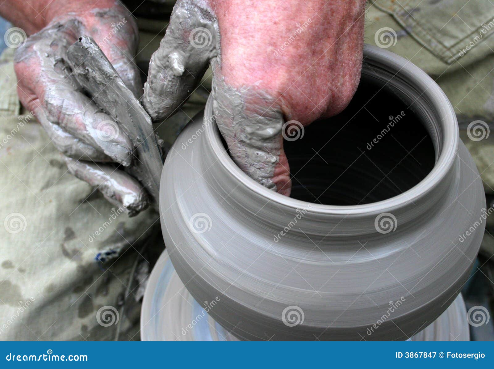 hands shaping clay on potter's wheel