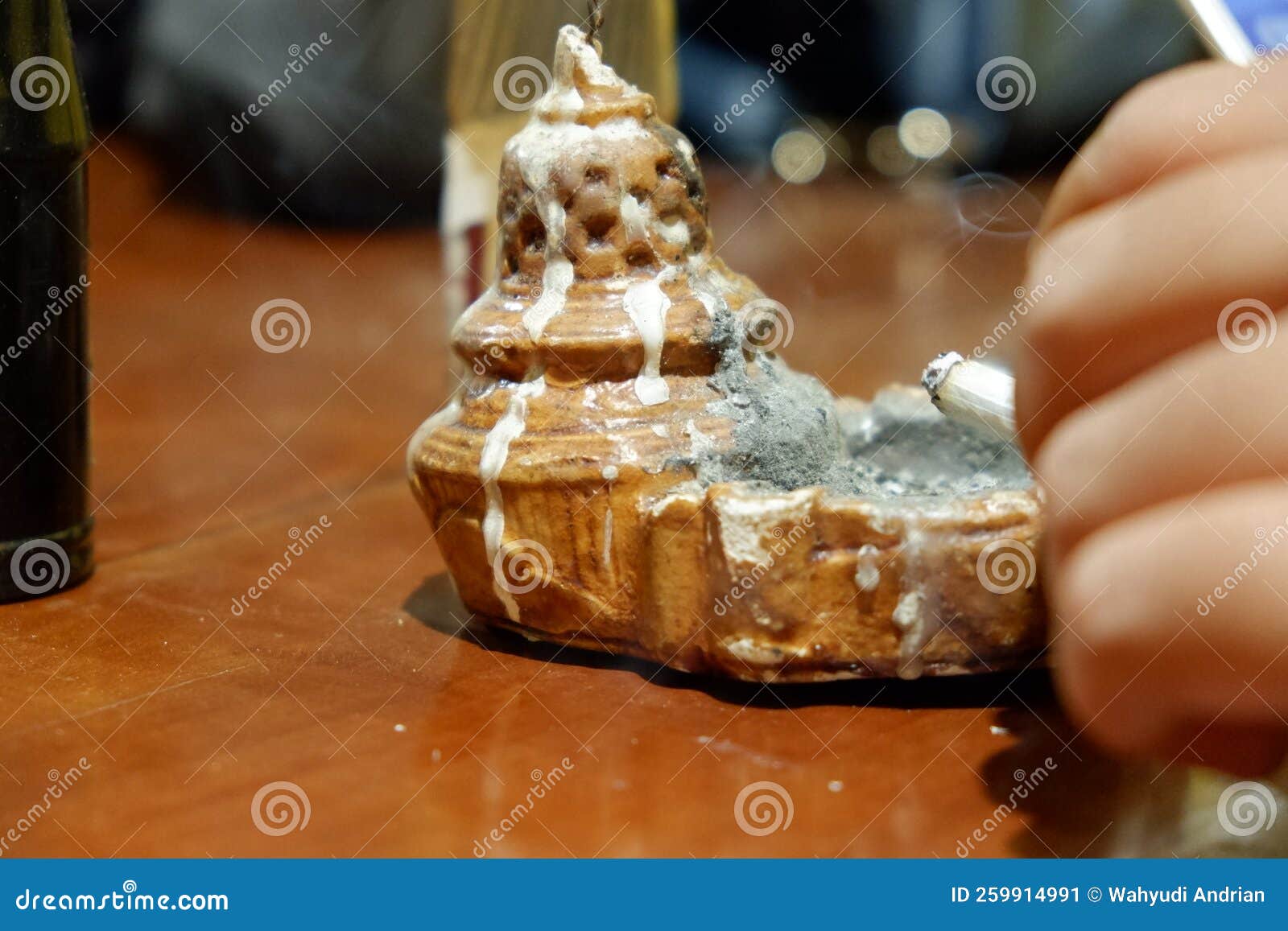 Hands Throwing Cigarette Butts in Templestyle Ashtrays Stock Image