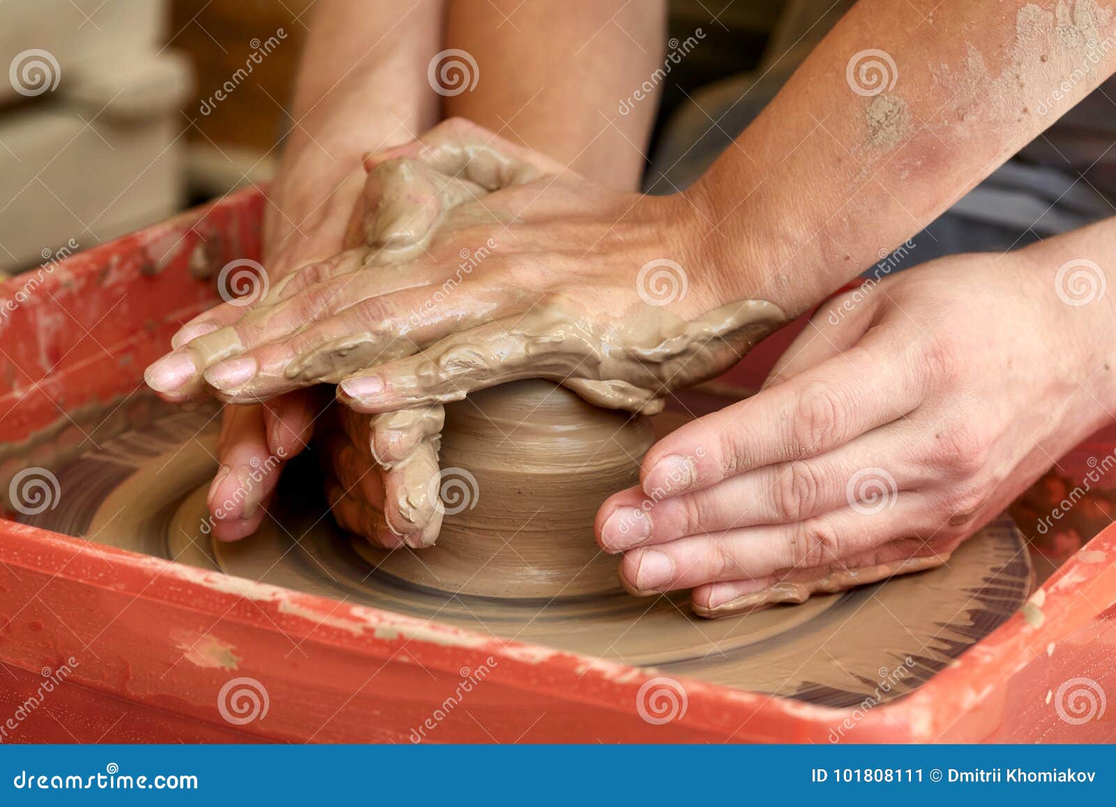 hands of two people create pot, potter`s wheel. teaching pottery