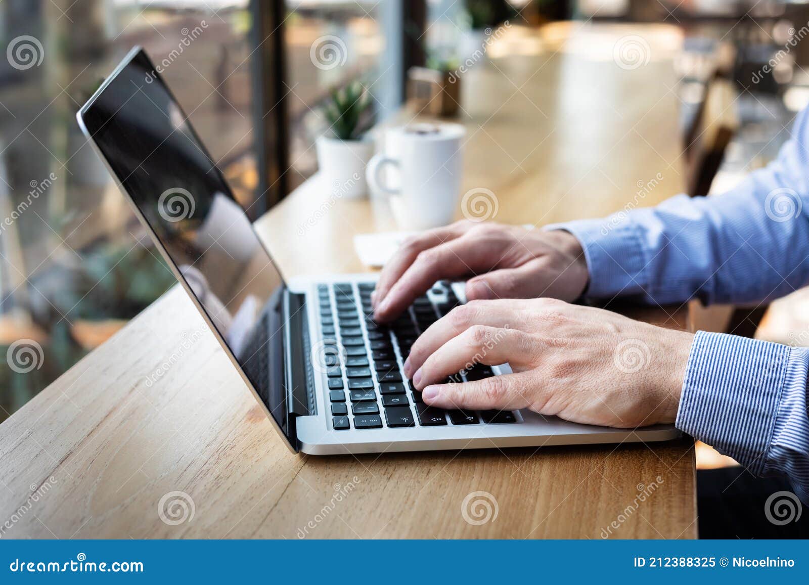 hands typing on laptop computer keyboard, person writing email or report document in cafe with coffee and wifi internet, casual