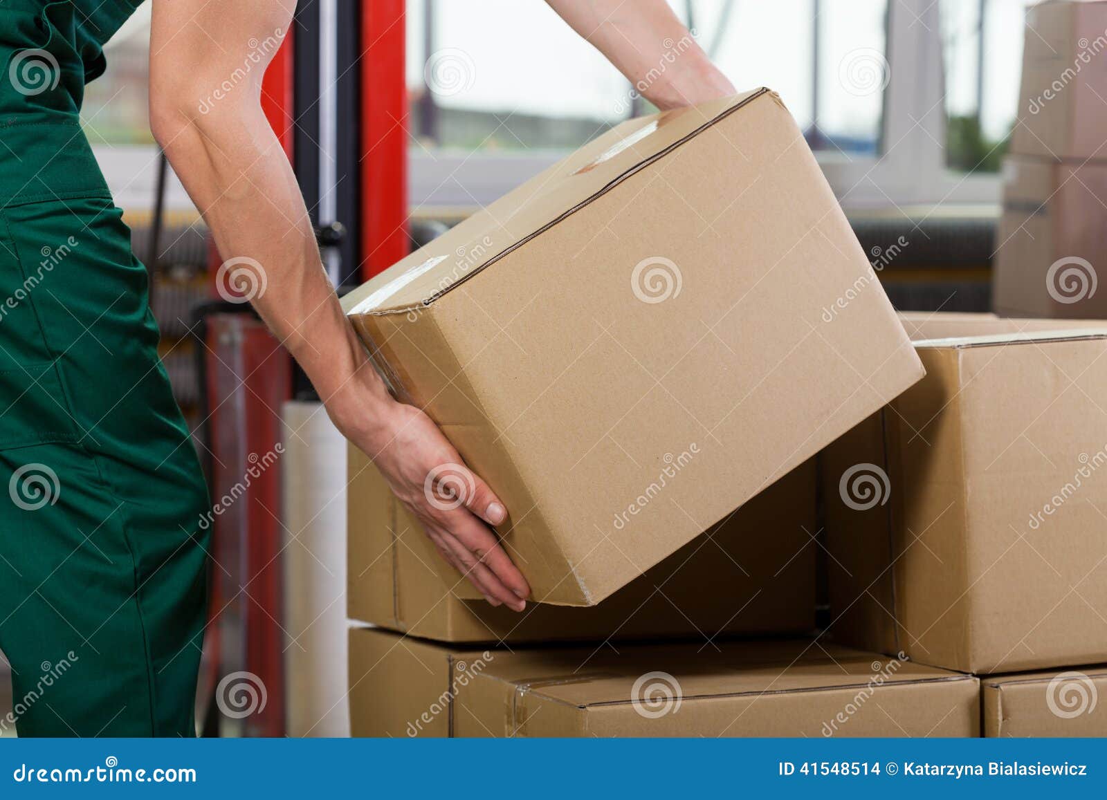 hands of warehouse worker lifting box