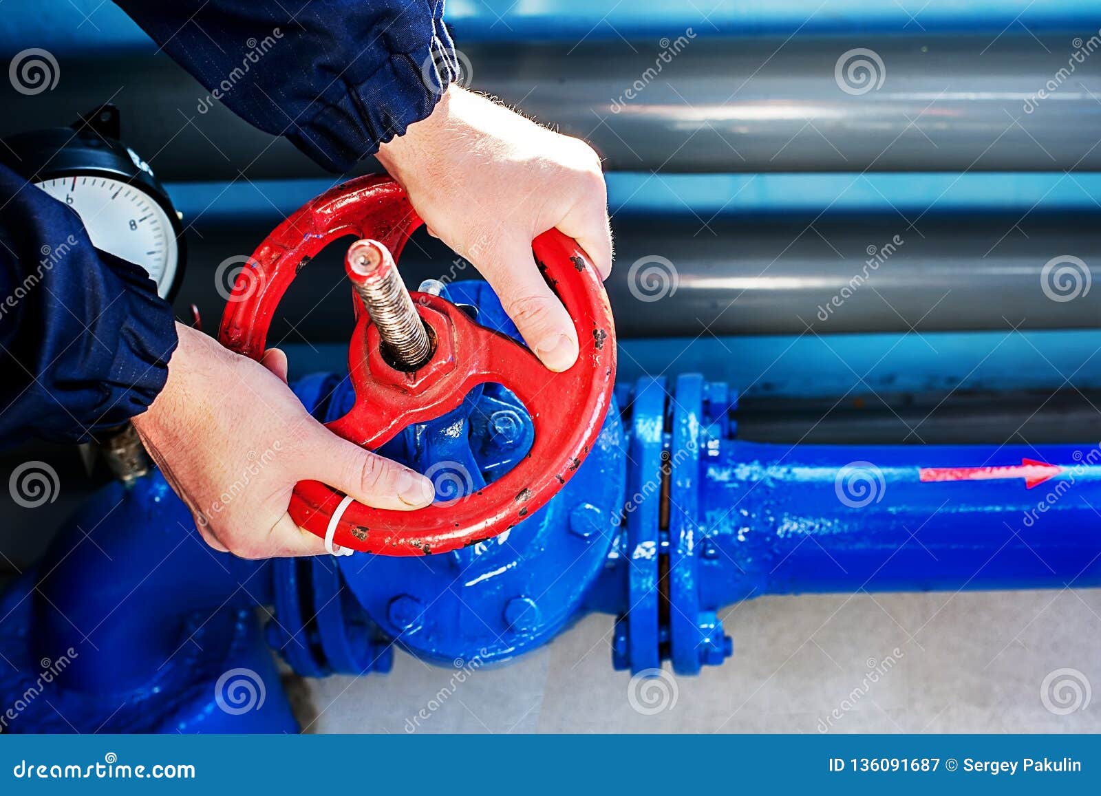 the hands of the worker unscrew rotate the red valve to supply the gas supply. top view close-up