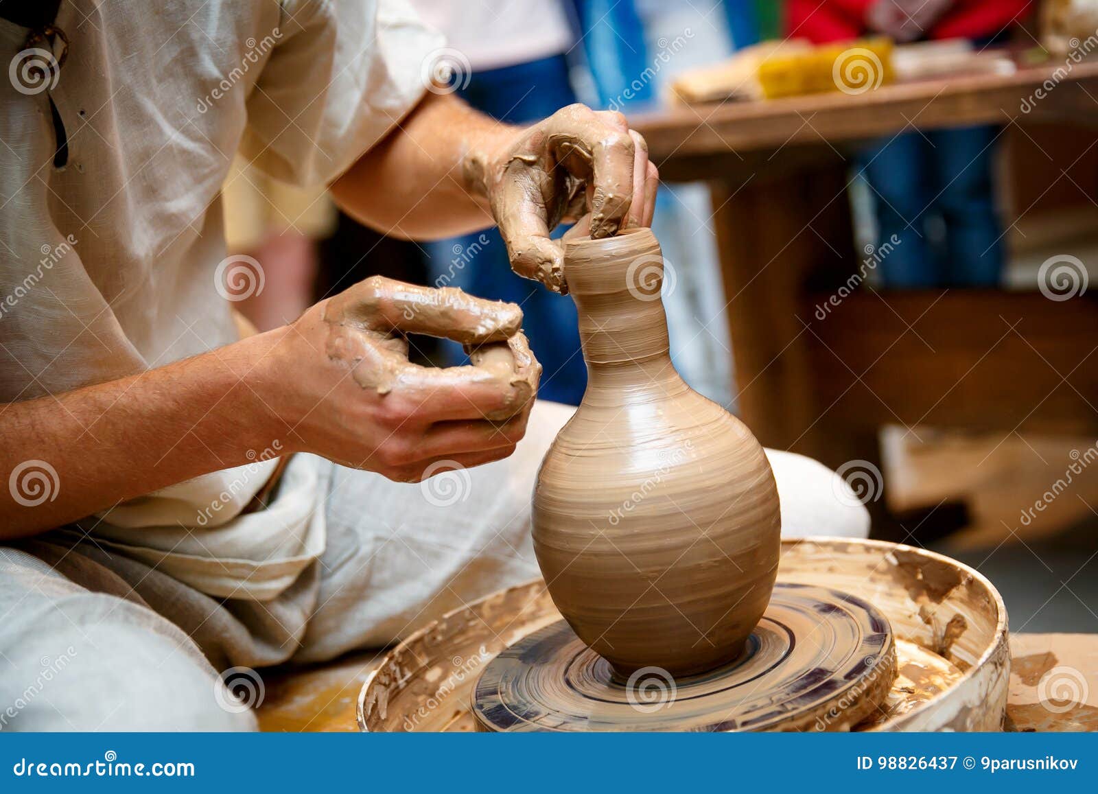 Hands of a potter sculpt clay dishes on a pottery wheel. Folk craft for  making dishes.