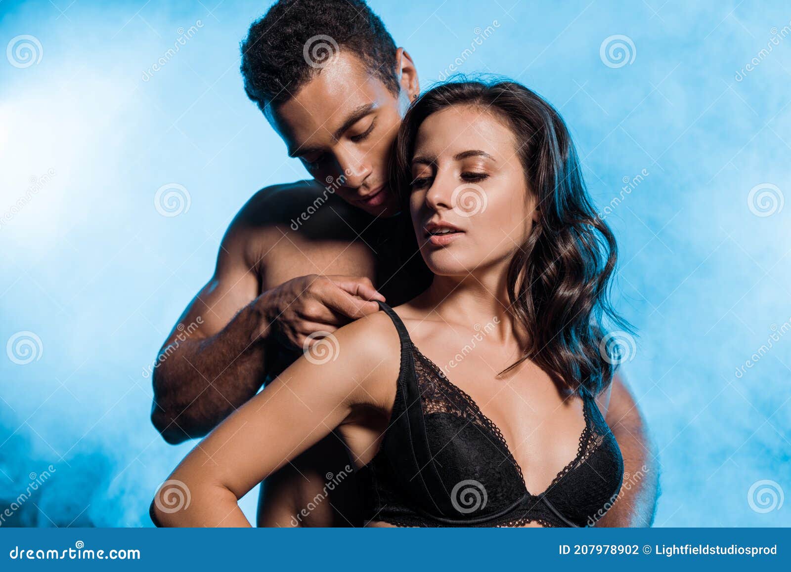 Handsome Bi-racial Man Touching Lace Black Bra of Girl on Blue with Smoke.  Stock Photo - Image of embrace, illumination: 207978902