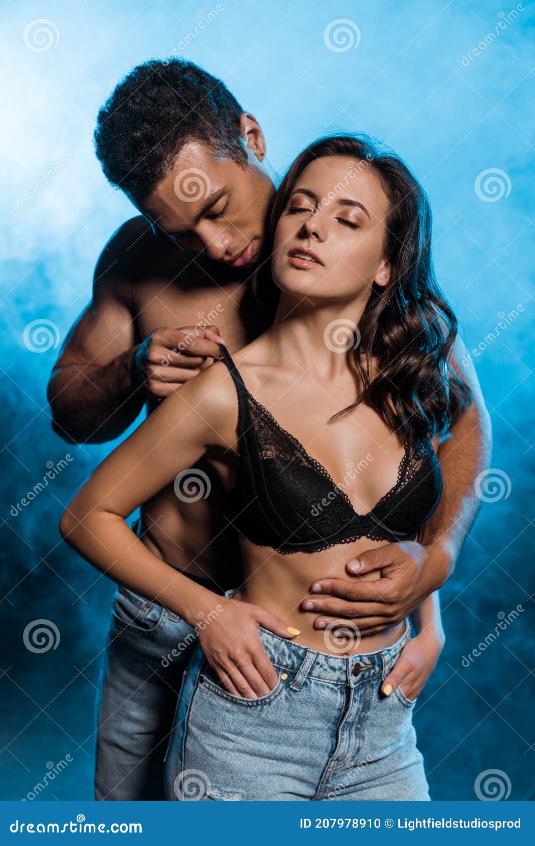 Handsome Bi-racial Man Touching Lace Bra of Girl on Blue with