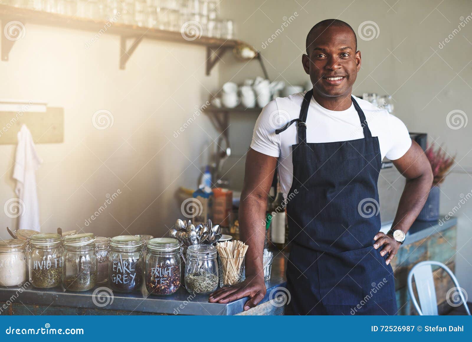 handsome black entrepreneur stands by cafe counter