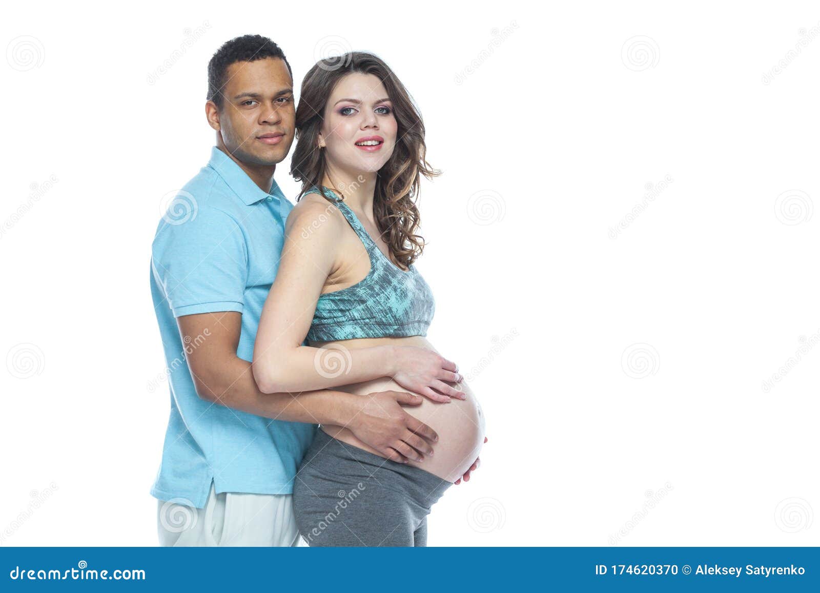 Handsome Black Man and His Beautiful Pregnant Wife are Hugging and Smiling while photo