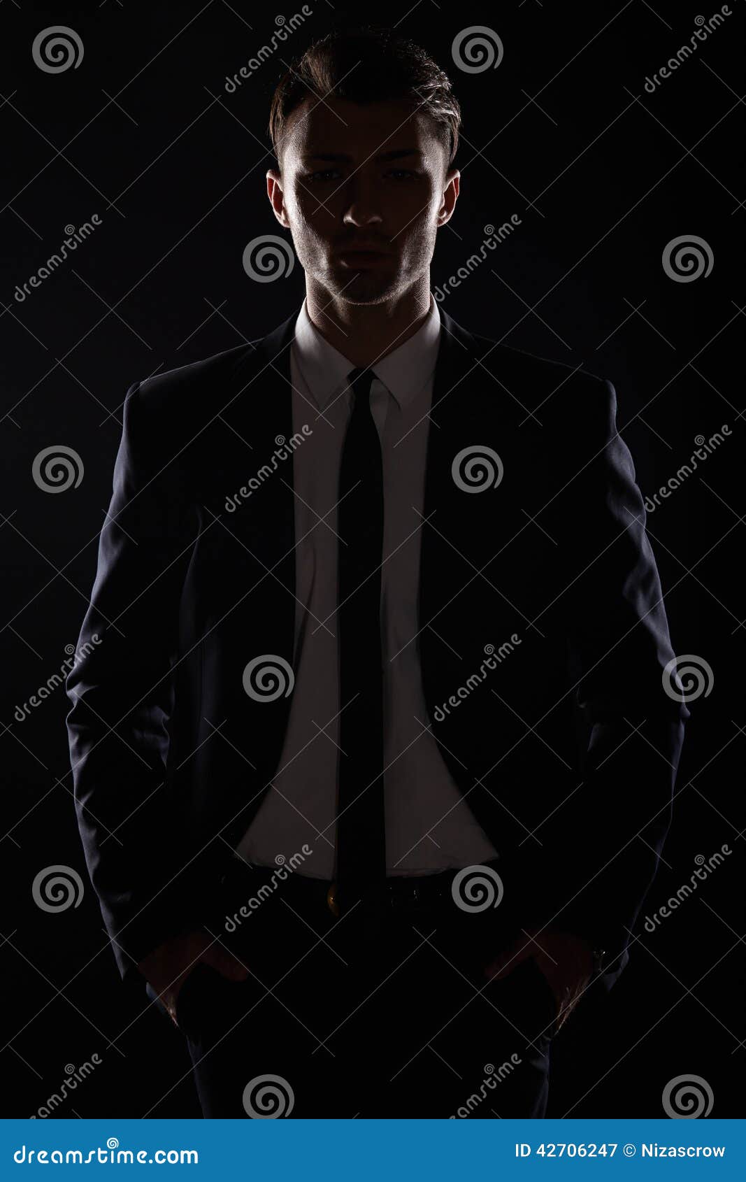 handsome business man in black suite, backlight