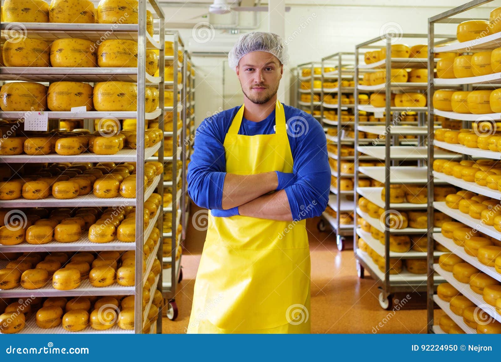 Handsome Cheesemaker is Checking Cheeses in His Storage. Stock