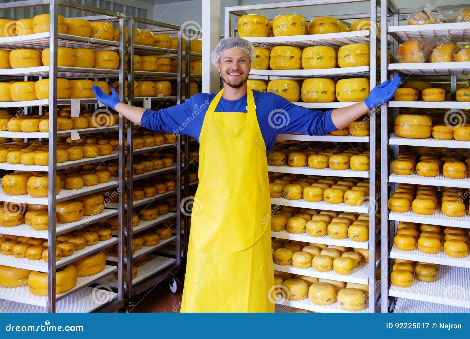 Handsome Cheesemaker is Checking Cheeses in His Storage. Stock Image Image of