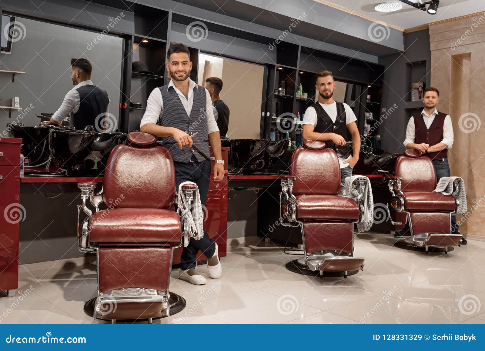 Confident Masters Barbers Standing Near Hairdresser Chairs And