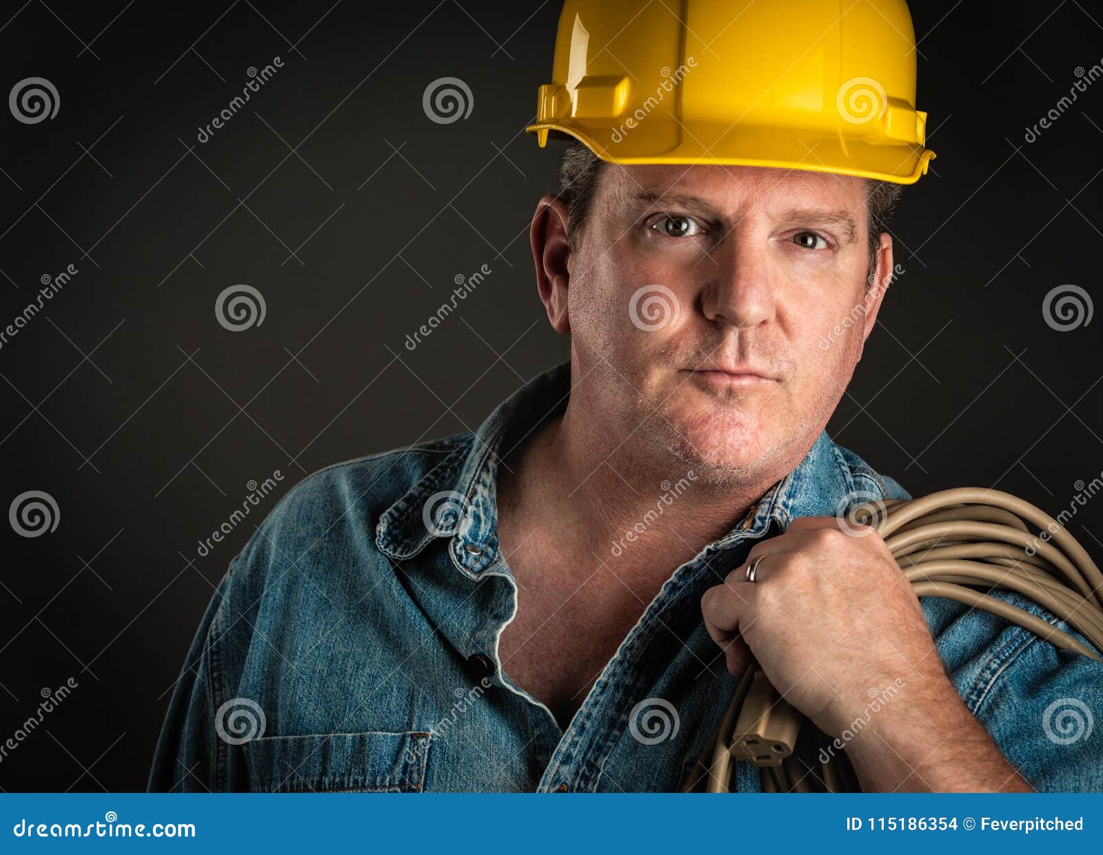 Serious Contractor In Hard Hat Holds Hammer With Dramatic Lighting