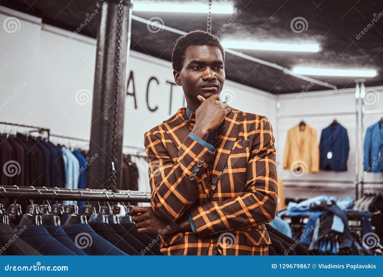 Elegantly Dressed African Man Posing with Hand on Chin while Standing ...