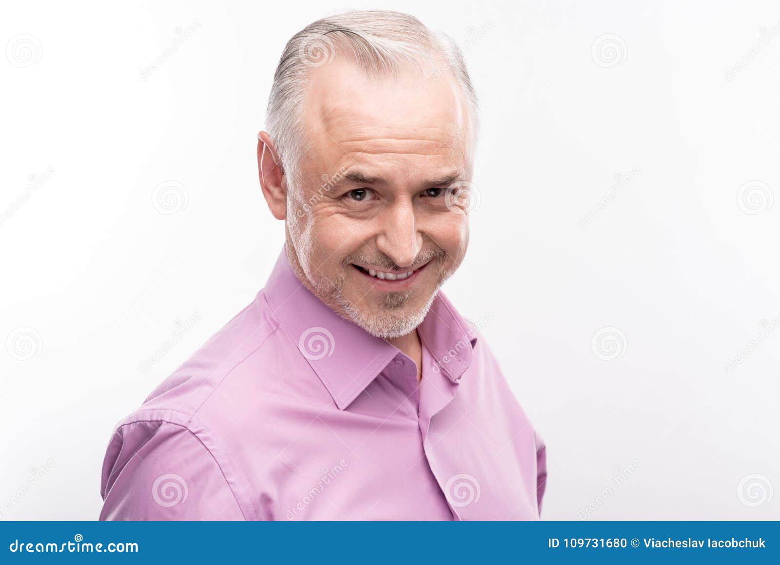 handsome grey-haired man smiling cheekily while posing