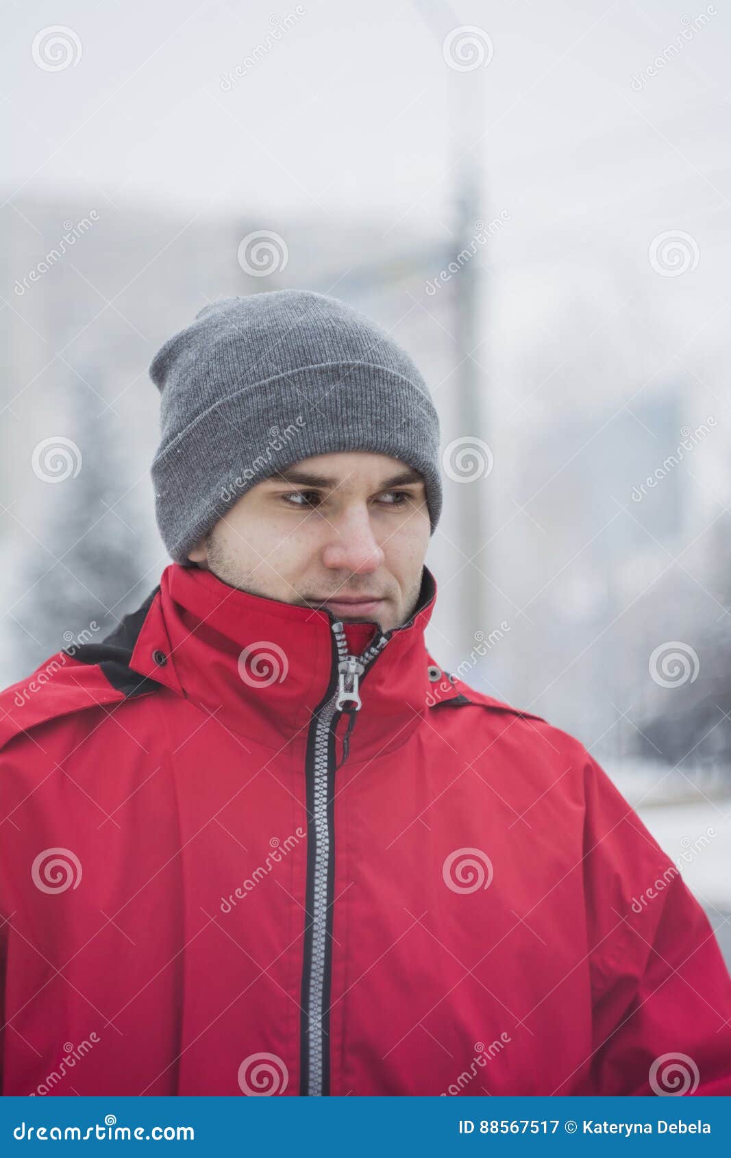 A Handsome Guy in a Gray Hat and a Red Jacket. he Looks Away ...