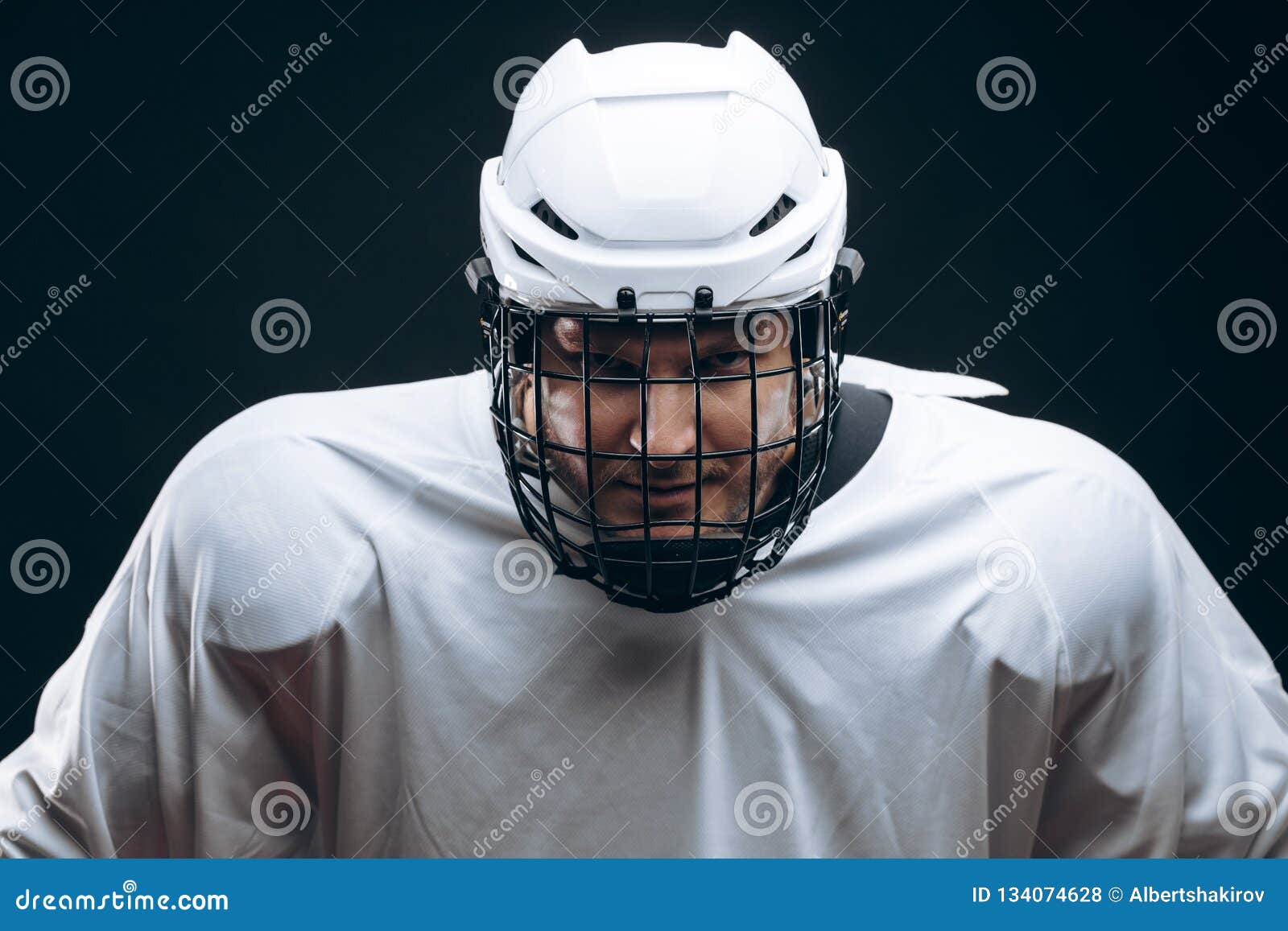 Handsome Hockey Player. Smiling at Camera Isolated on Black Background