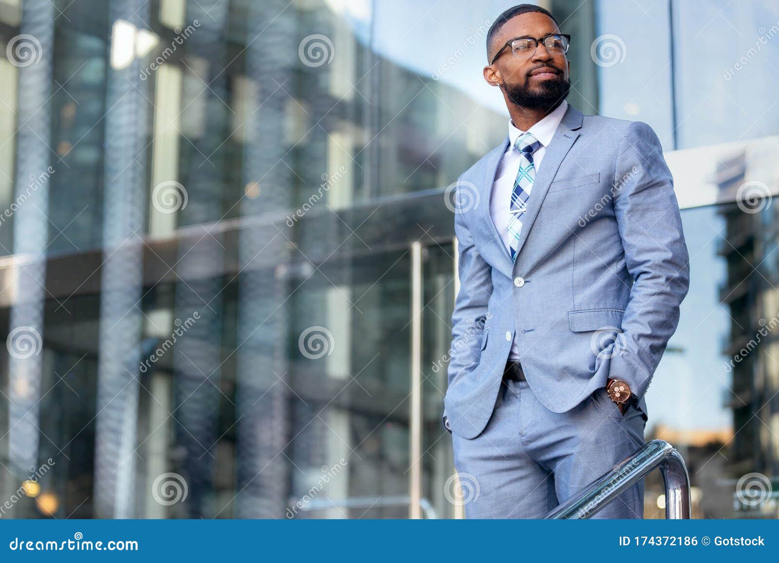 handsome male african american business man ceo in a stylish chic suit at the workplace, standing confidently in front of financia