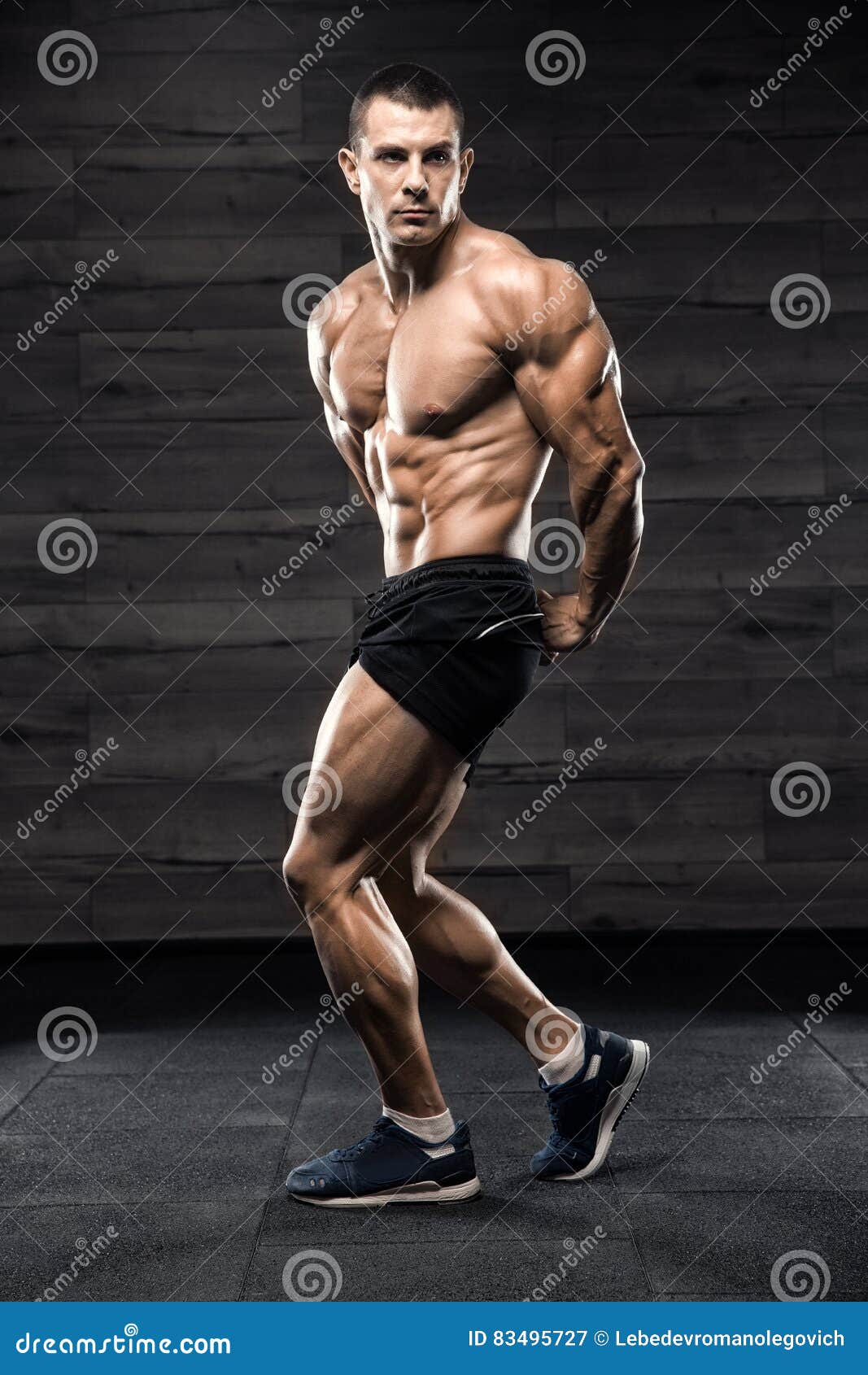 Handsome Man with Big Muscles, Posing at the Camera in the Gym Stock