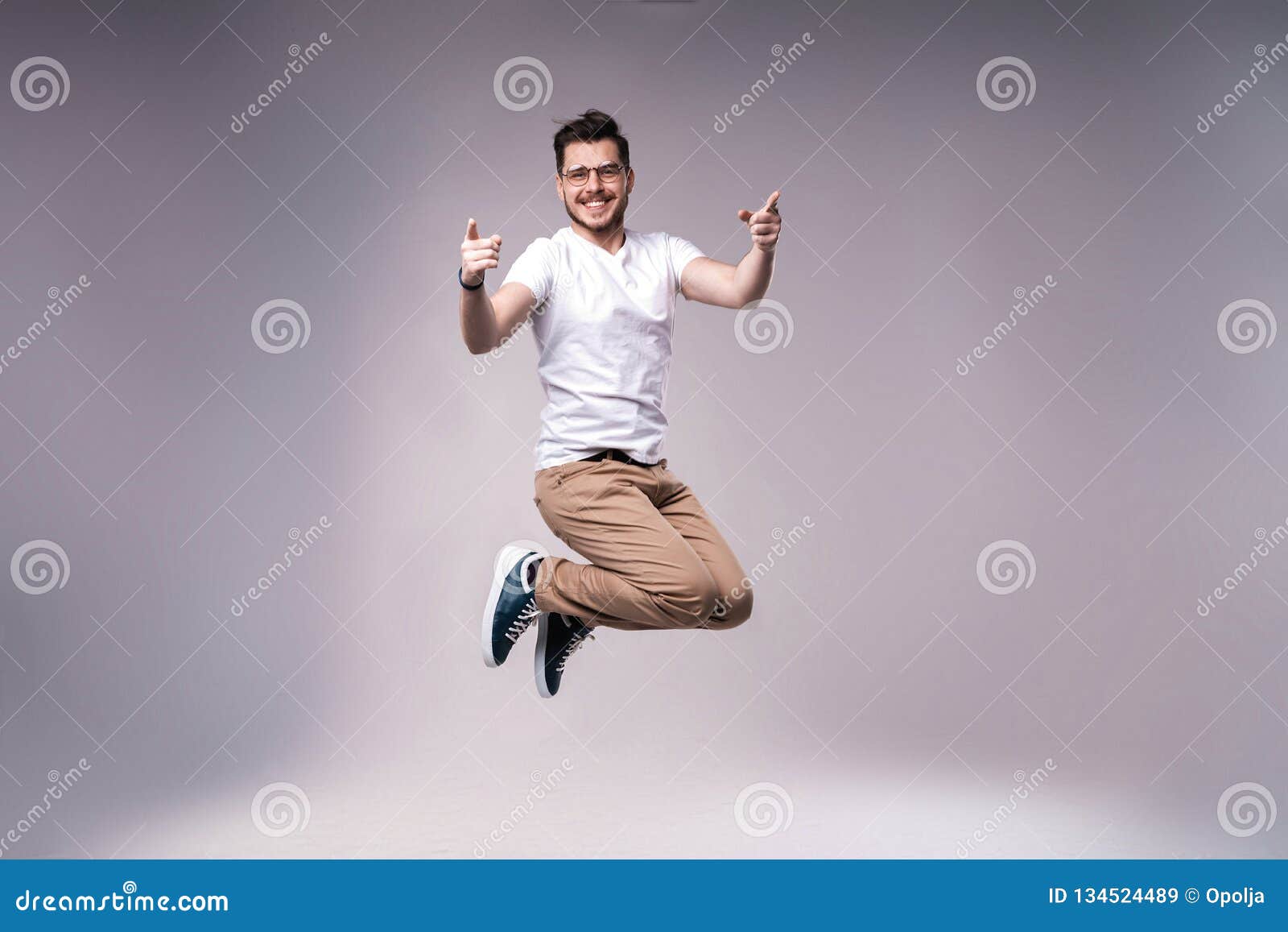 Handsome Man Casual Dressed Celebrating and Jumping on Gray Background ...