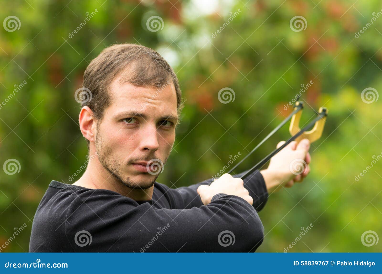 Handsome Man Concentrated Aiming a Slingshot at Stock Image Image of