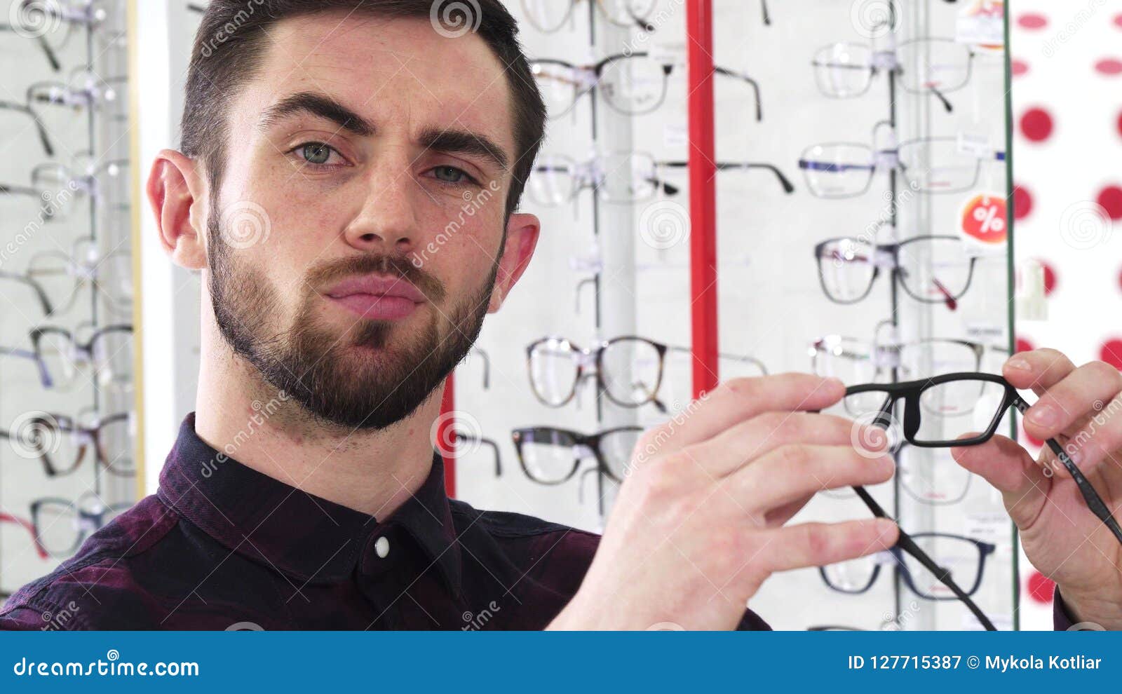 Handsome Man Examining Pair of Glasses at the Optometrists Store Stock ...