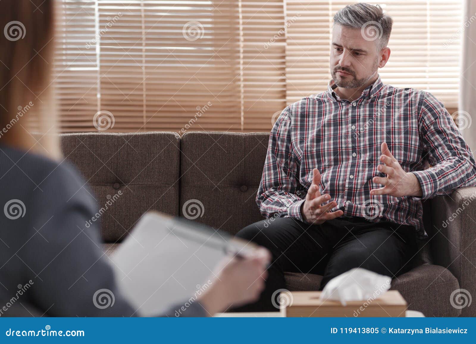 handsome man gesticulating while talking to his psychologist during a therapy