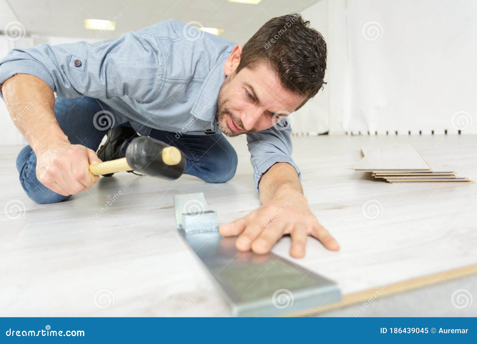 Handsome Man Measuring Wooden Flooring With Hammer Stock Image Image Of Tool Floor 186439045