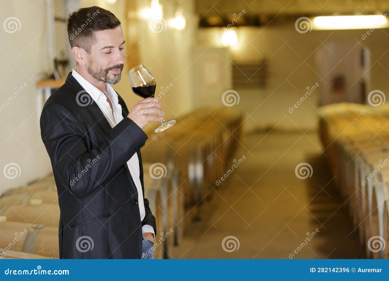 Handsome Man Sommelier Tasting Red Wine in Cellar Stock Photo Image