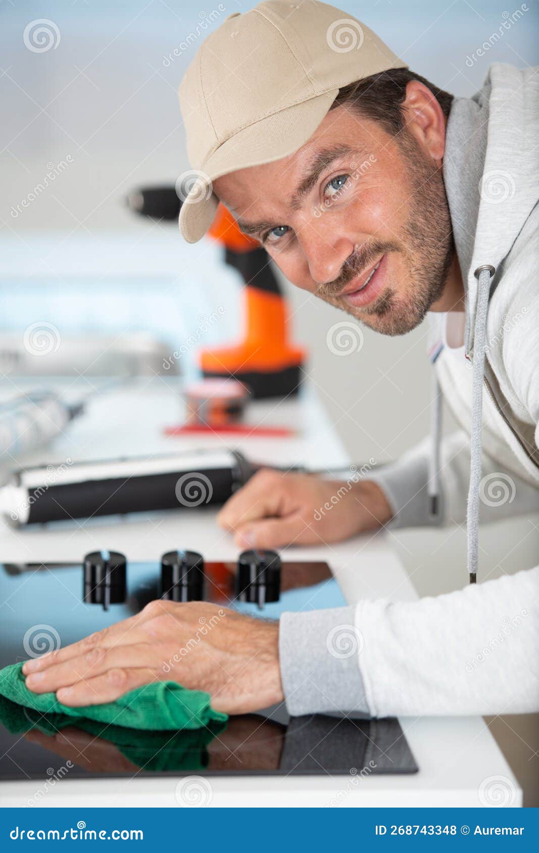handsome man using detergent to cleaning hob