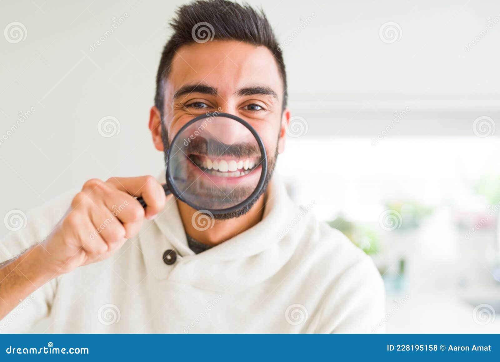 Handsome Man Using Magnifying Glass, Doing Funny Faces Stock Photo