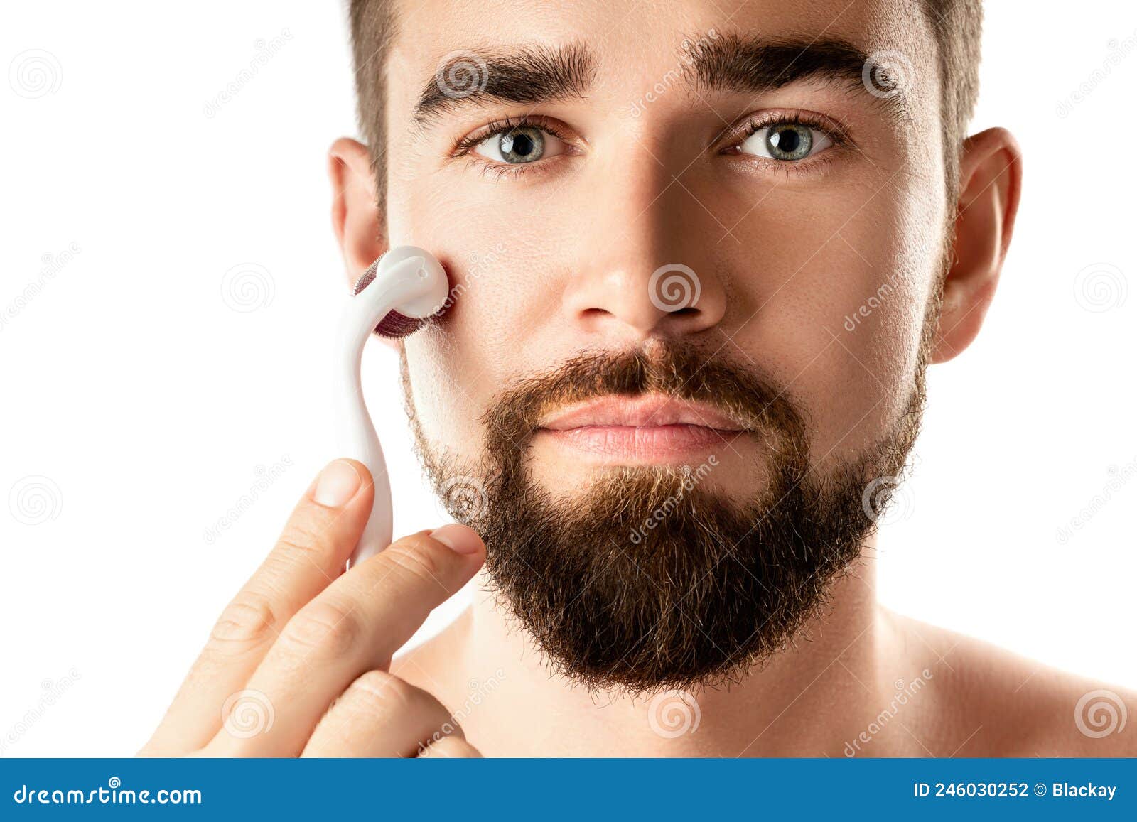 handsome man using meso roller for better beard growth