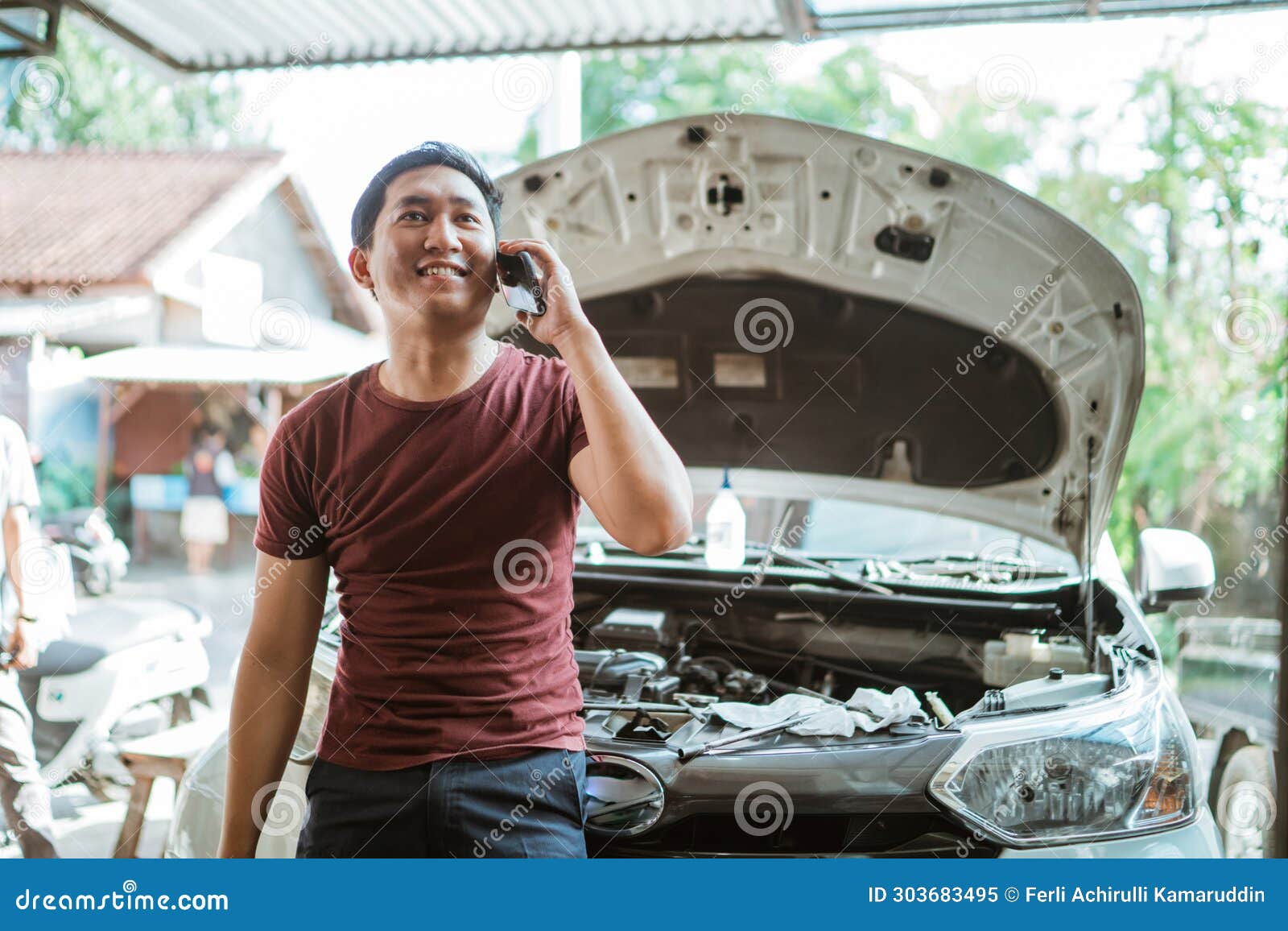Handsome Mechanic Makes a Cell Phone Call during a Break Stock Image