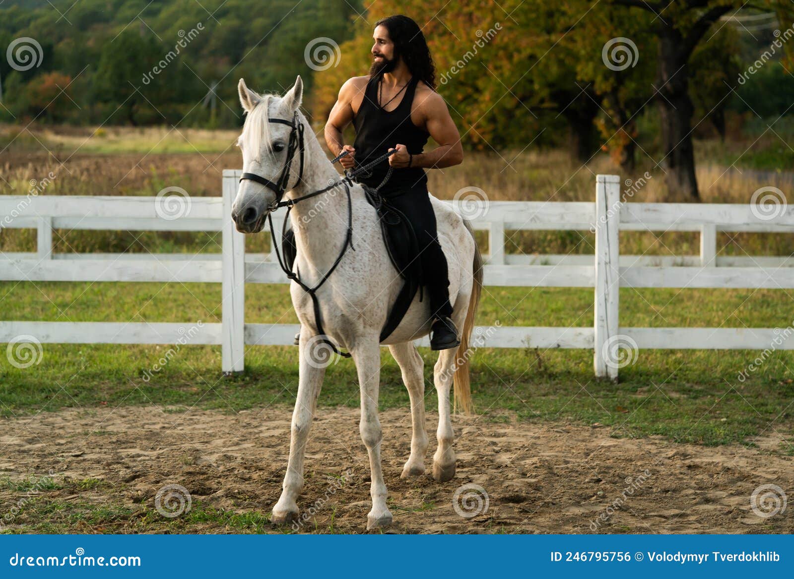handsome muscular man riding horse. hunky cowboy. young muscular guy in t-shirt on horseback.