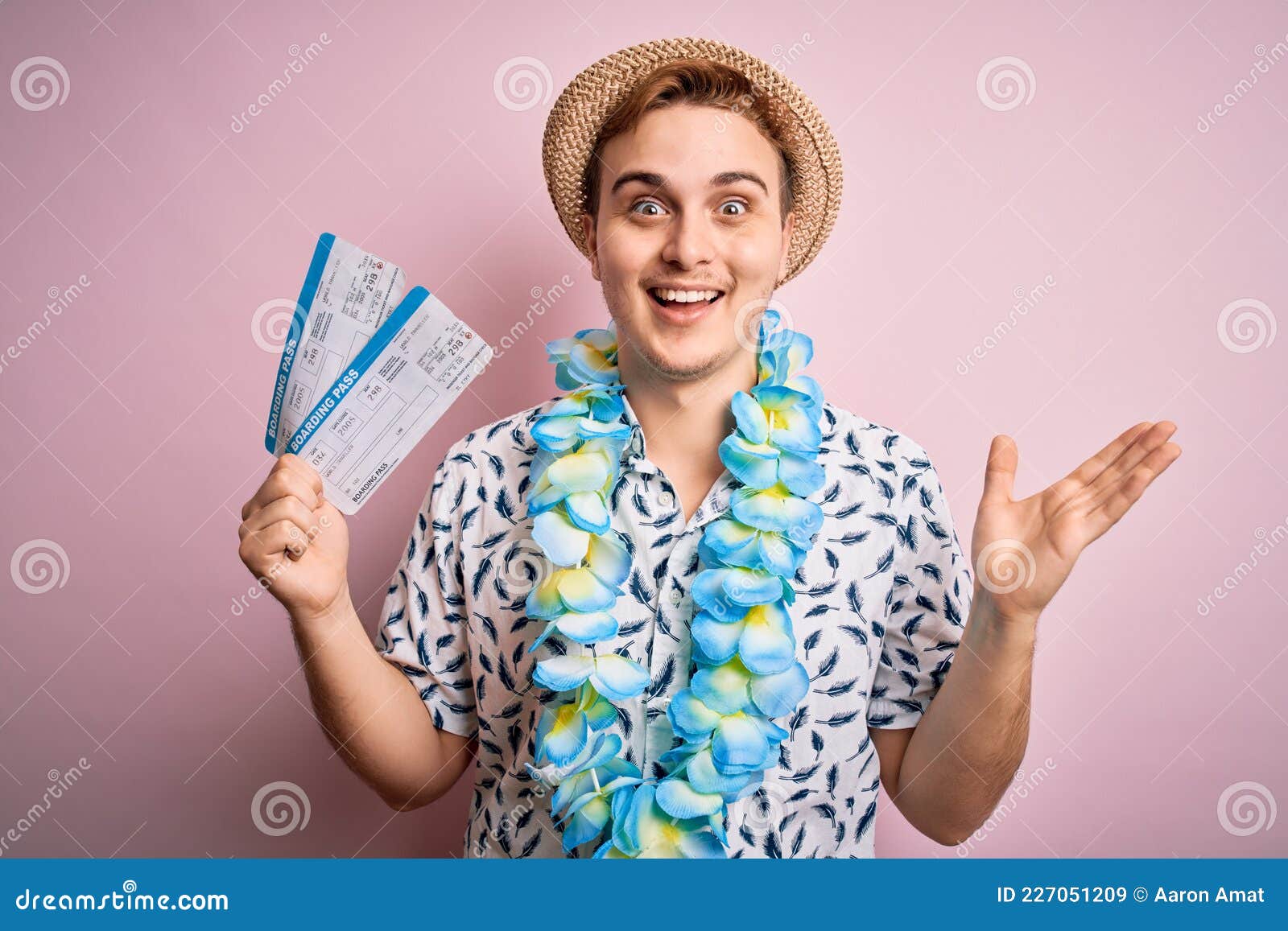 handsome redhead tourist man on vacation wearing hawaiian lei holding boarding pass airlane celebrating victory with happy smile
