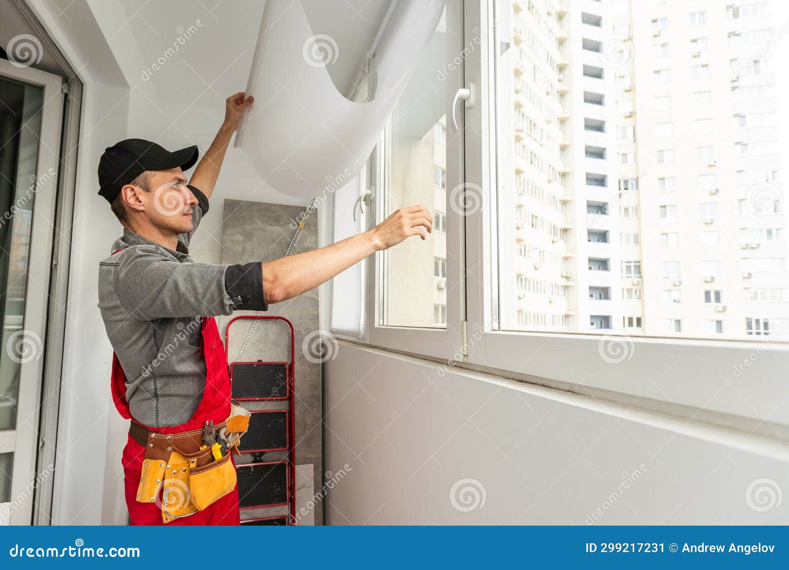 Handsome Repairman in Goggles Measuring Wall Near Window Stock Image