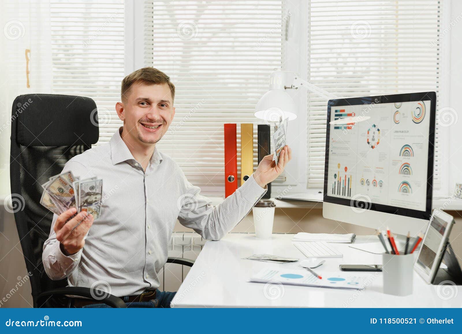 serious and engrossed business man in shirt sitting at the desk, working at computer with modern monitor. manager or worker.