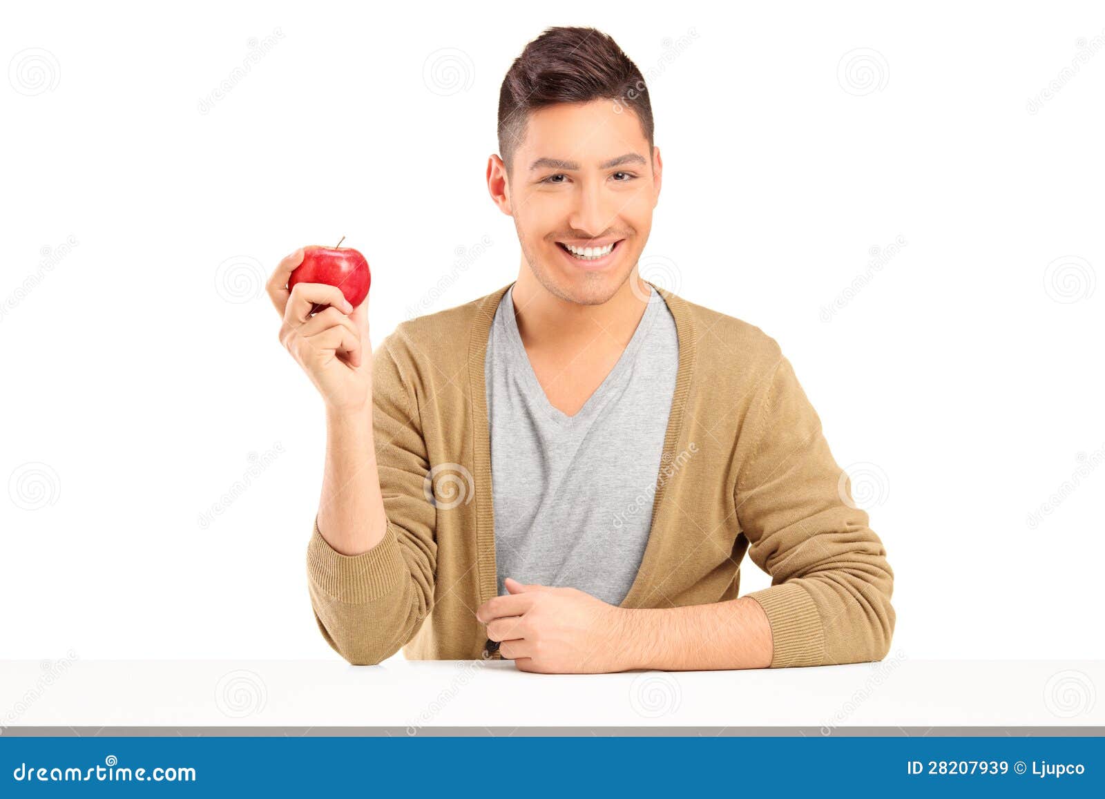 Handsome Smiling Guy Holding a Red Apple and Posing on a Table Stock ...