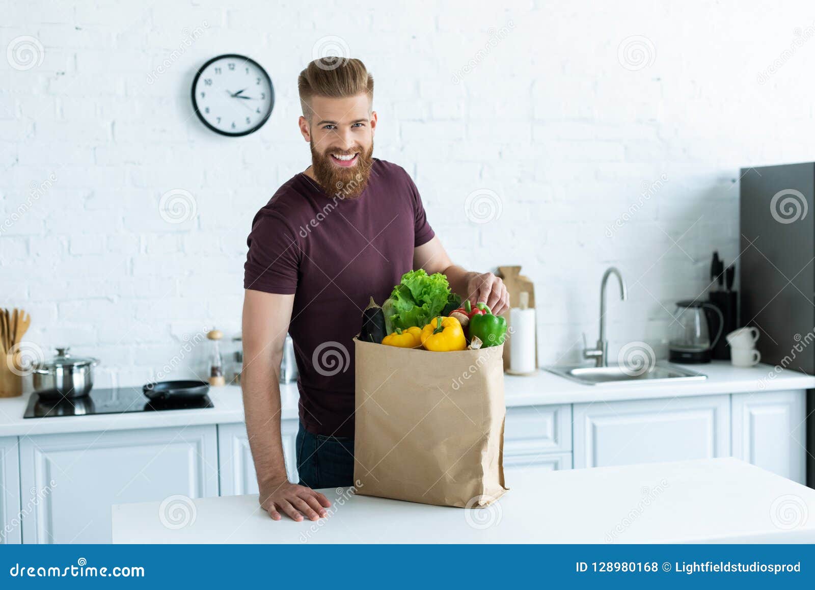 Handsome Smiling Young Man Leaning at Kitchen Table with Grocery Bag Stock Photo Image of