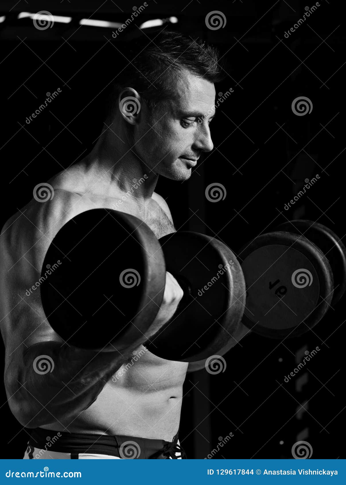 Handsome Strong Angry Man Doing the Exercises with Dumbbells on Stock ...