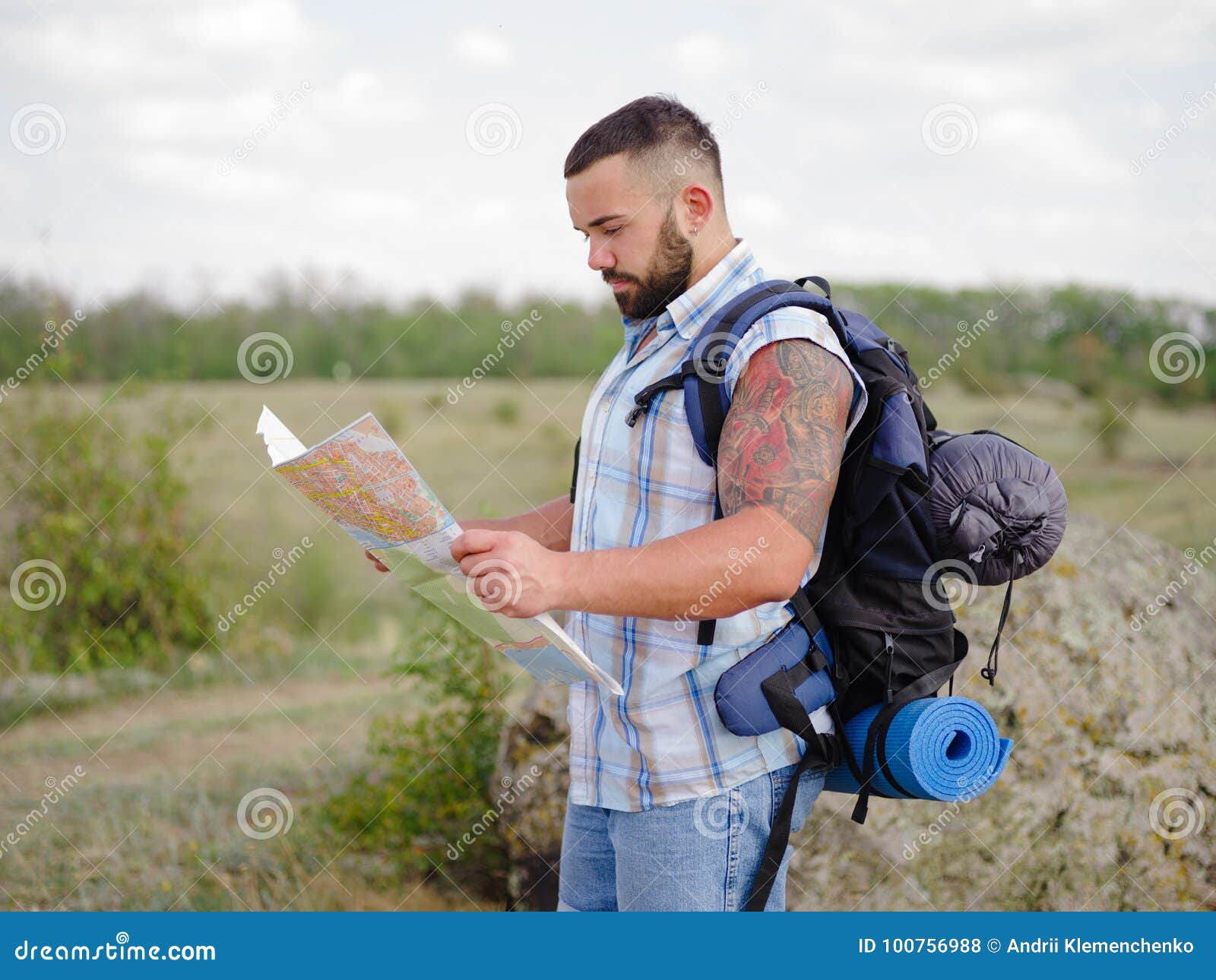 Strong Bearded Hiking Guide Looking at the Map on a Natural Background ...